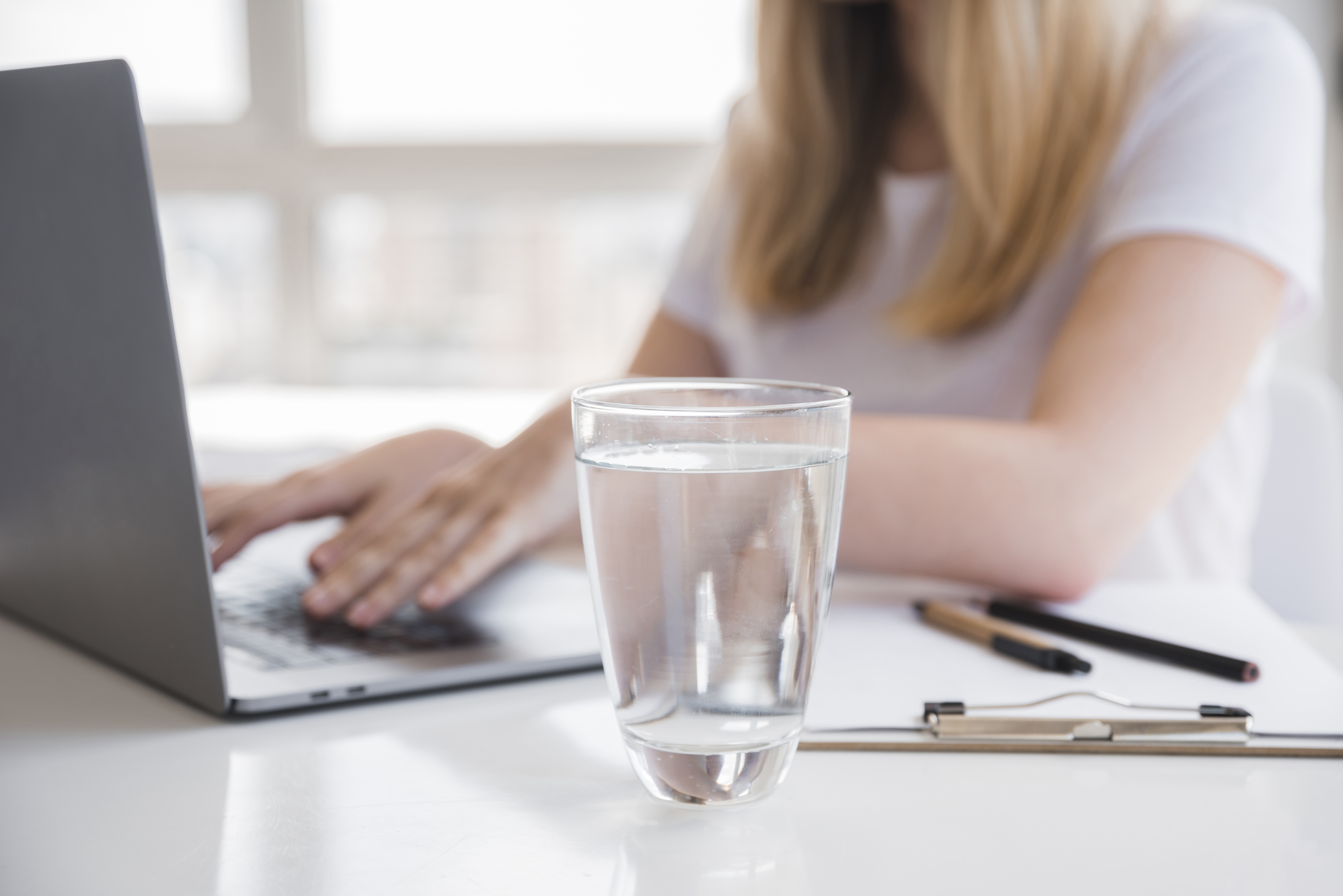 fille-en-bonne-sante-a-l-aide-d-un-ordinateur-portable-avec-un-verre-d-eau